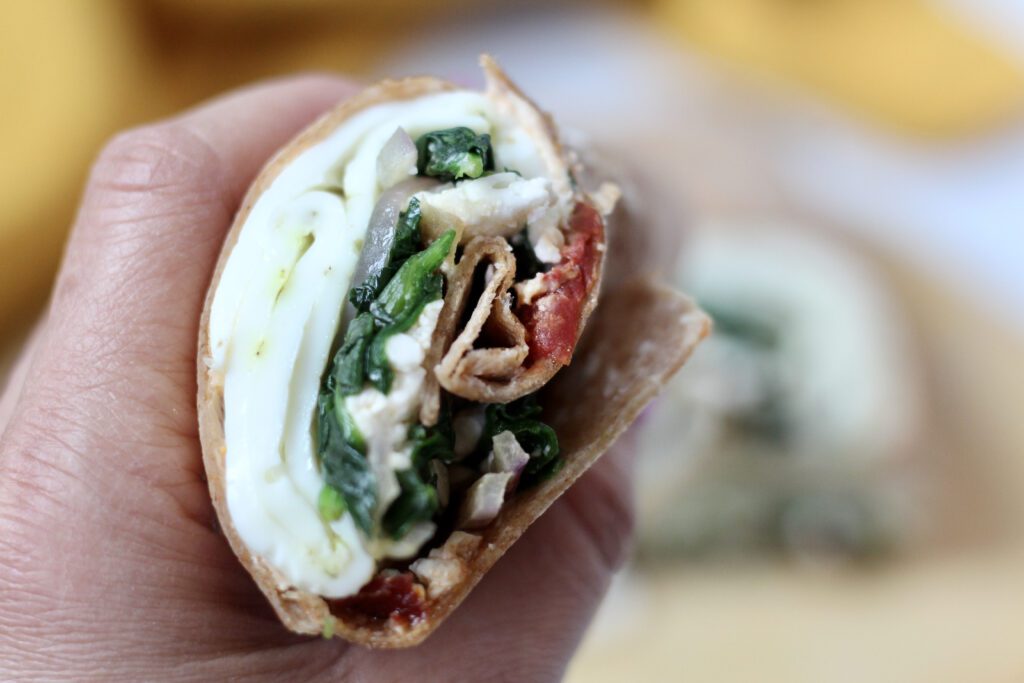 Spinach feta breakfast wrap held