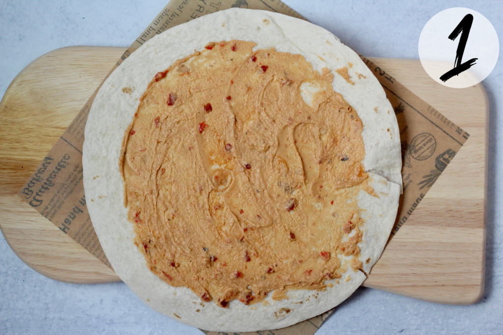 Spread hummus on tortilla