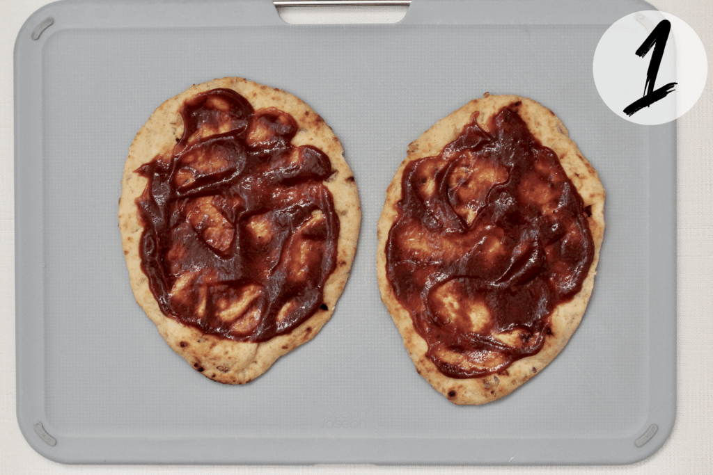 Spread BBQ sauce on naan bread