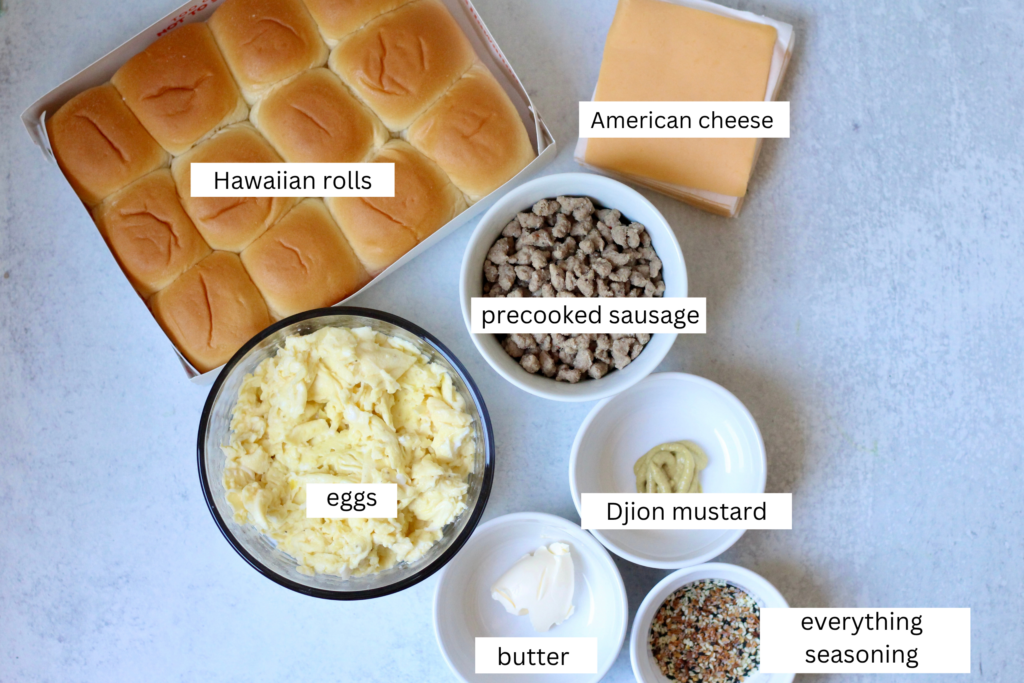 Ingredients for breakfast sliders including Hawaiian rolls, scrambled eggs, turkey sausage, cheese, butter, Dijon and everything bagel seasoning