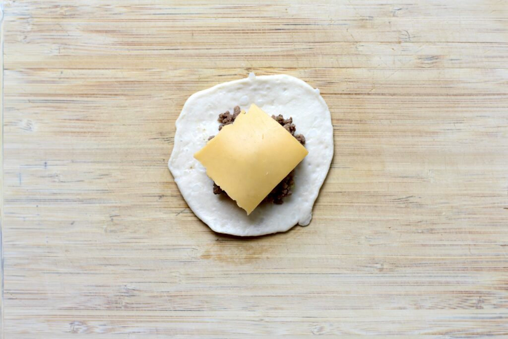 American cheese layered over beef and caramelized onions in biscuit dough