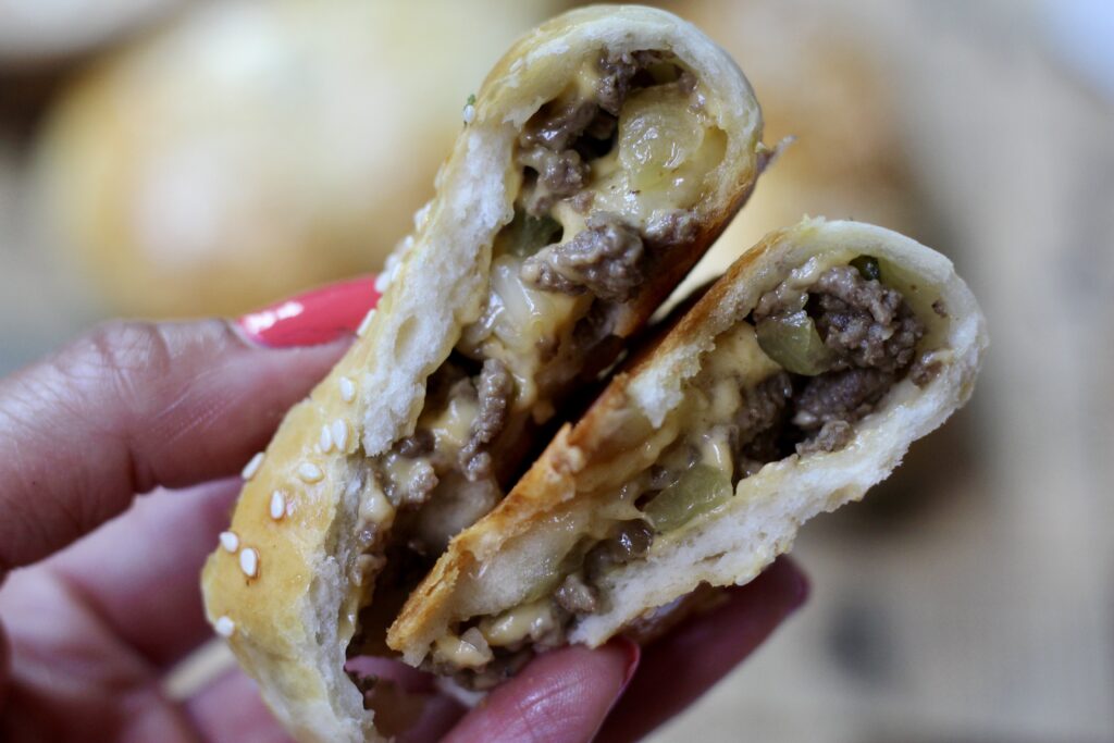 Inside of a cheeseburger bomb filled with seasoned beef, pickles, caramelized onion and melted American cheese