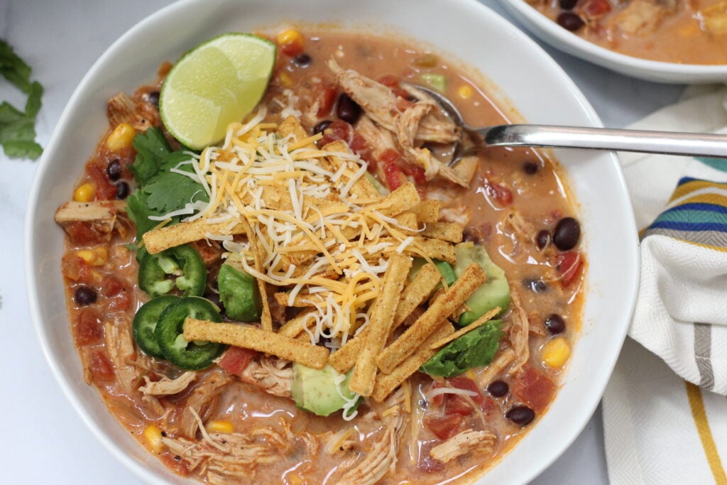 Creamy chicken tortilla soup topped with shredded cheese, avocado, jalapeños and tortilla strips.
