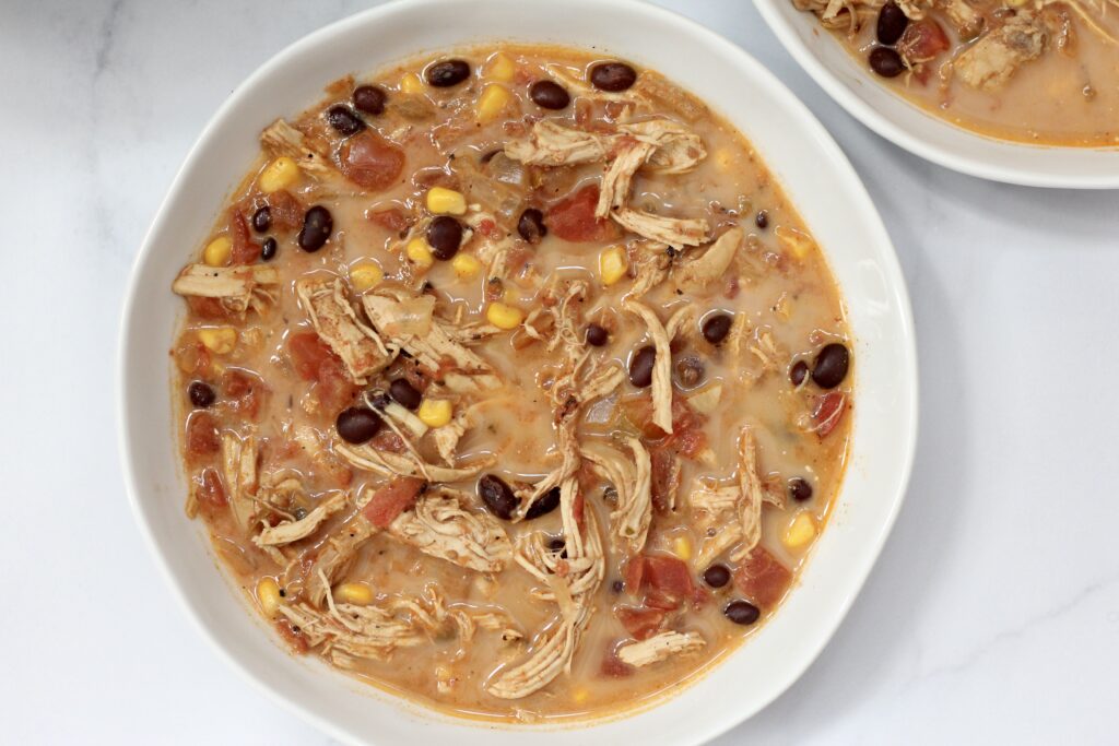 Creamy chicken tortilla soup with shredded chicken, black beans, corn and tomatoes.